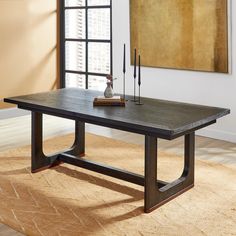 a wooden table sitting on top of a rug in a living room next to a window