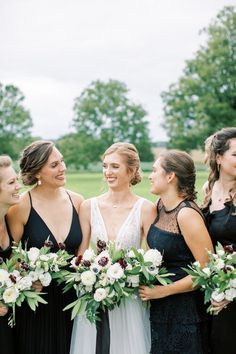 a group of women standing next to each other holding bouquets in their hands and laughing