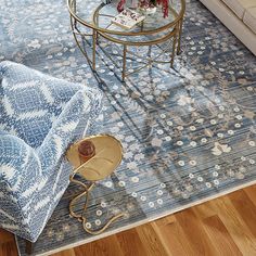 a living room with a blue and white rug on the floor next to a coffee table