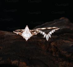 two engagement rings on top of a tree branch with diamonds in the middle and side