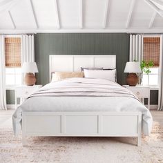 a white bed sitting in a bedroom on top of a carpeted floor next to two lamps