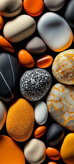 some rocks and pebbles are arranged together on the ground with orange, white, and black colors