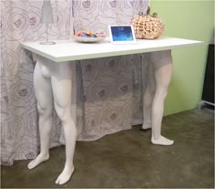 two mannequins are standing next to a table with a tablet on it