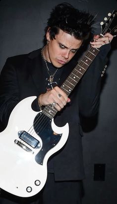 a man holding an electric guitar in his right hand