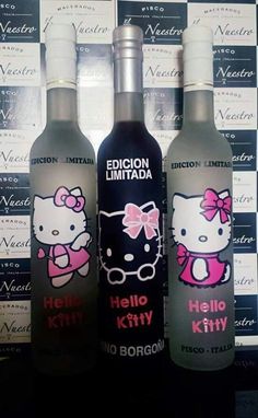 three bottles of hello kitty vodka sitting next to each other on a table with wallpaper in the background