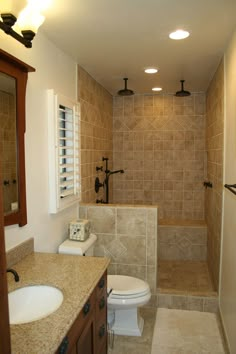 a bathroom with a toilet, sink and shower stall is shown in this image from the inside