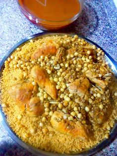 a bowl filled with food sitting on top of a table next to an orange container