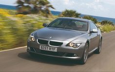 a silver bmw car driving down the road