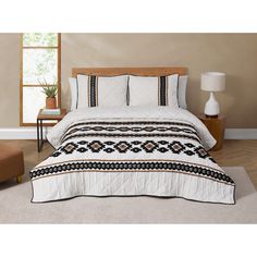 a bed with white and black bedspread in a room