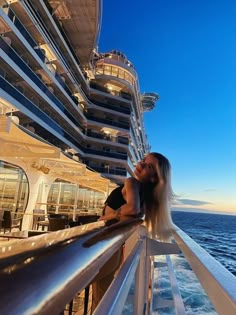 a woman leaning on the railing of a cruise ship