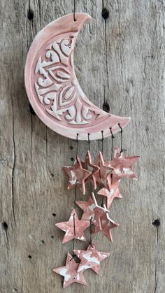 a pink moon and stars hanging on a wooden wall