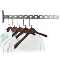 three wooden hangers with clothes hanging on them and two white shirts in the background