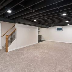 an empty living room with stairs leading up to the second floor