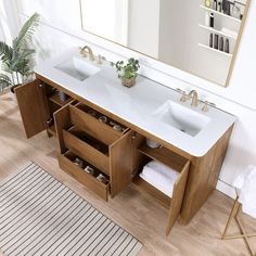 a bathroom vanity with two sinks and a large mirror over the sink, in front of a rug