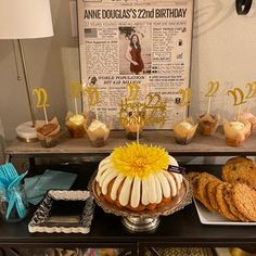 a table topped with cakes and desserts next to a newspaper