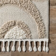 an area rug with tassels and fringe on the bottom is laying on a wooden floor