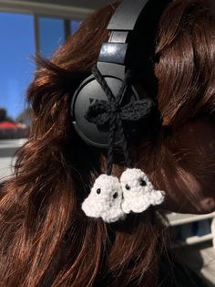 a close up of a person wearing headphones with two crocheted headsets