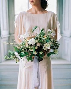 a woman holding a bouquet of flowers in her hands