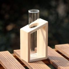 a glass vase sitting on top of a wooden pallet next to a bottle opener