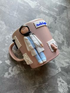 a cake in the shape of a mug with a female figure on it and writing