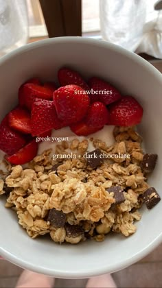 a bowl filled with granola, chocolate chips and strawberries