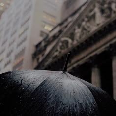 an umbrella with rain drops on it in front of a building