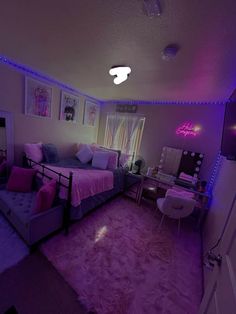 a bedroom with purple and blue lights on the ceiling, pink bedding and rugs