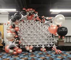 balloons and streamers are arranged on the floor in front of a backdrop made of circles