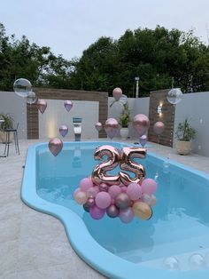 a pool with balloons floating in it and the number twenty