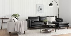 a living room with black leather furniture and white walls