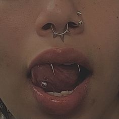 a woman with piercings on her nose and tongue