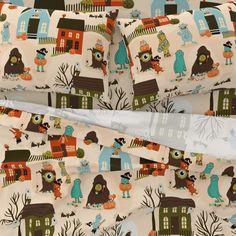 the bedding is made up with colorful houses and owls