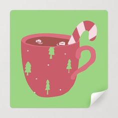 a pink mug with candy cane in it on a green background