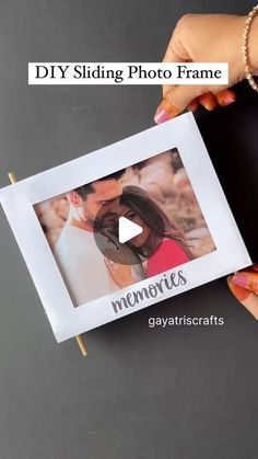 a woman holding up a photo frame with the words diy sliding photo frame on it