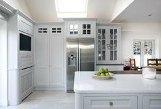 a large kitchen with white cabinets and stainless steel appliances, including a dishwasher