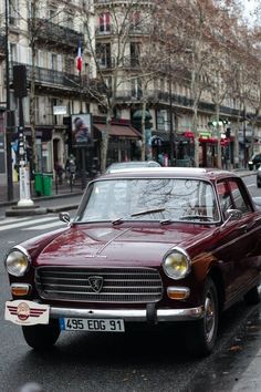 an old car is parked on the side of the street