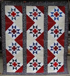 a red, white and blue quilt hanging from a line