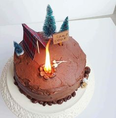 there is a cake that has been decorated with trees and a camp sign on it