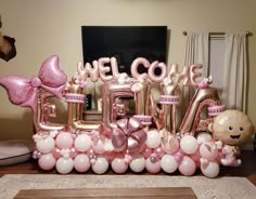 a welcome home sign made out of balloons and helium letters with teddy bears on them