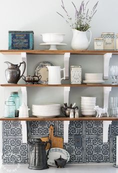 a kitchen shelf filled with dishes and cups