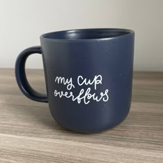 a blue coffee mug with the words my cup is overflowing on it's side