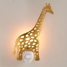 a gold giraffe night light on a white wall