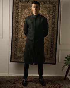 This stunning black sherwani epitomizes geometric sharpness, boasting intricate tonal embroidery on a silk base. Each stitch is meticulously handcrafted to perfection, creating an illusion of fabric that mesmerizes the eye. With its impeccable craftsmanship and attention to detail, this sherwani stands as a true testament to sophistication and style, making it the ideal choice for any formal occasion or cultural celebration.From Jigar & Nikita's Summer Romance collection. DELIVERY TIMEPlease all Ceremonial Black Kurta With Naqshi Detailing, Ceremonial Black Kurta With Naqshi, Designer Black Straight Kurta, Designer Black Kurta With Naqshi, Black Nehru Jacket With Zari Work, Black Sherwani With Chikankari Embroidery, Black Chikankari Embroidered Sherwani, Black Bandhgala Straight Kurta, Black Chikankari Embroidery Sherwani