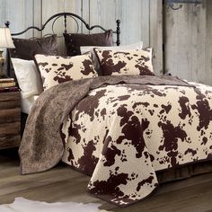 a brown and white cow print comforter on a bed