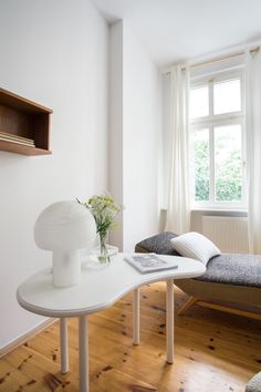 a bedroom with a bed, desk and shelves on the wall next to each other