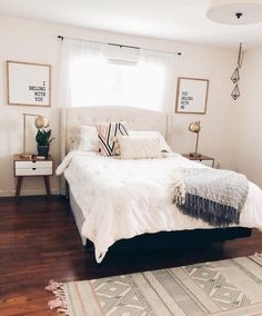 a white bed sitting in a bedroom on top of a hard wood floor