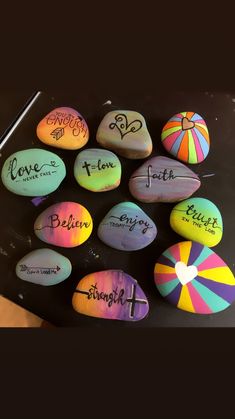 some colorful rocks with writing on them and an umbrella in the middle that says love