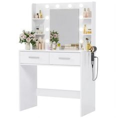 a white vanity with lights and flowers on it