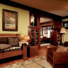 a living room filled with lots of furniture and paintings on the wall above it's windows