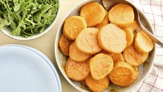 a bowl filled with cut up potatoes next to a plate of lettuce